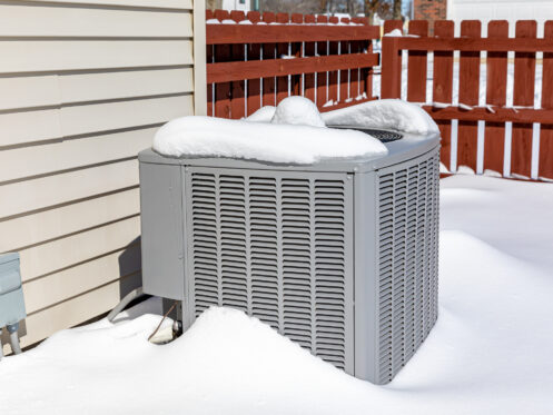 Outdoor AC unit blanketed in snow