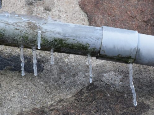 Frozen pipe with icicles forming